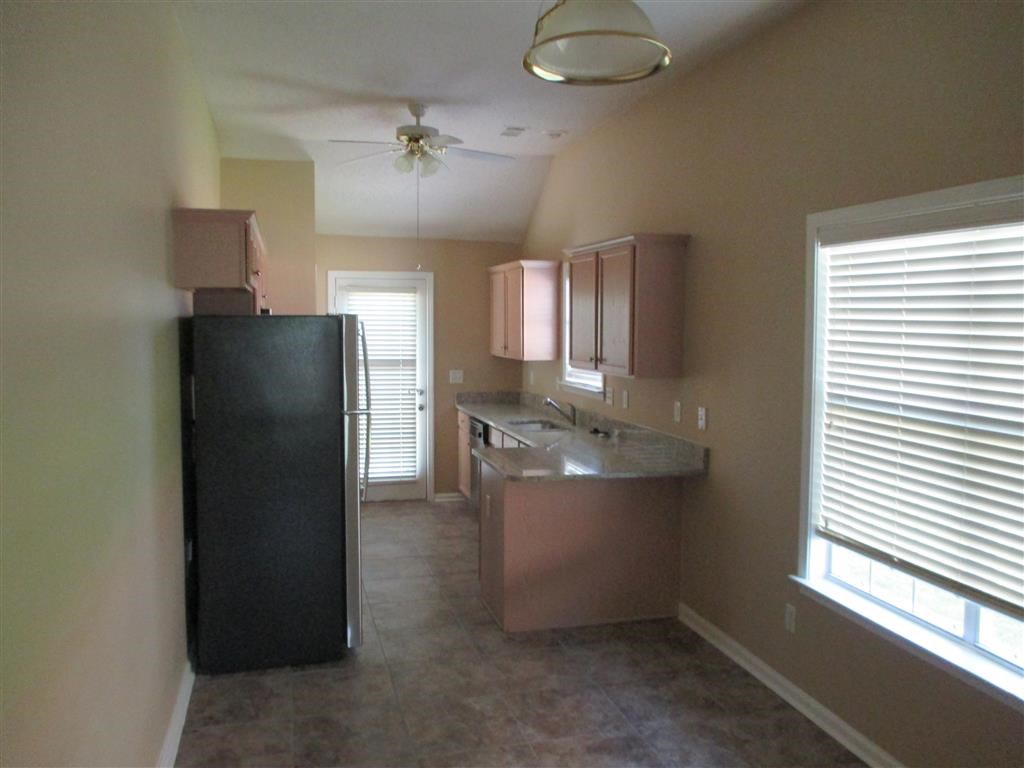 a kitchen with a black refrigerator and a sink