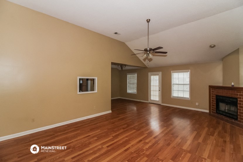 the living room with wood floors and a fireplace