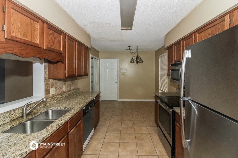 a kitchen with stainless steel appliances and wooden cabinets