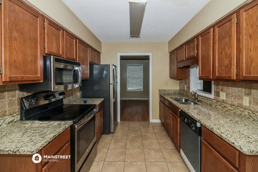 a kitchen with wood cabinets and black appliances and granite counter tops