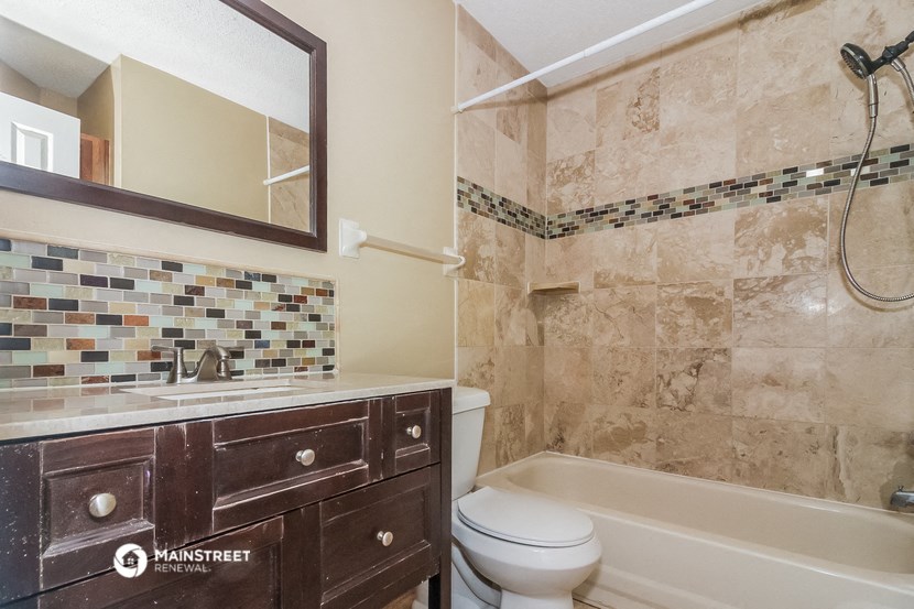 a bathroom with a toilet and a tub and a sink