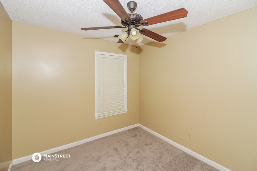 the interior of a bedroom with a ceiling fan