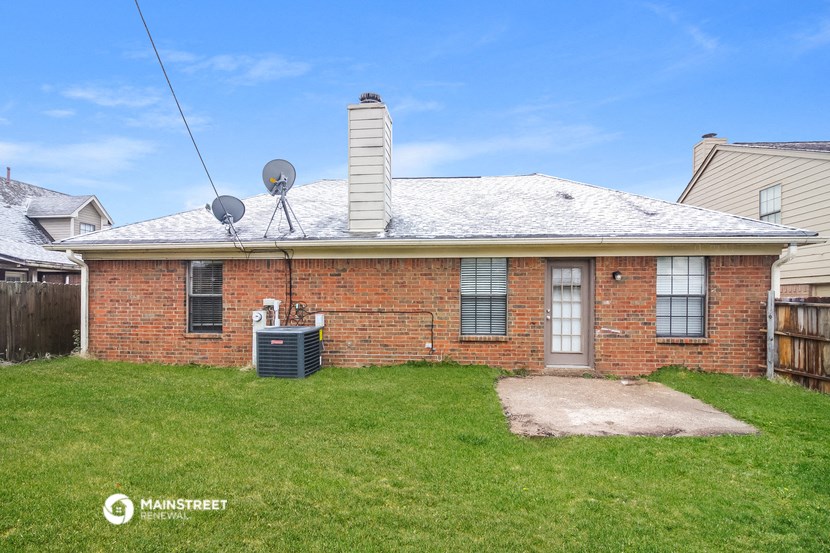 a small brick house with a yard and a roof