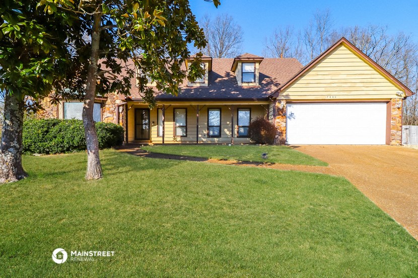 the front of a house with a yard and a garage