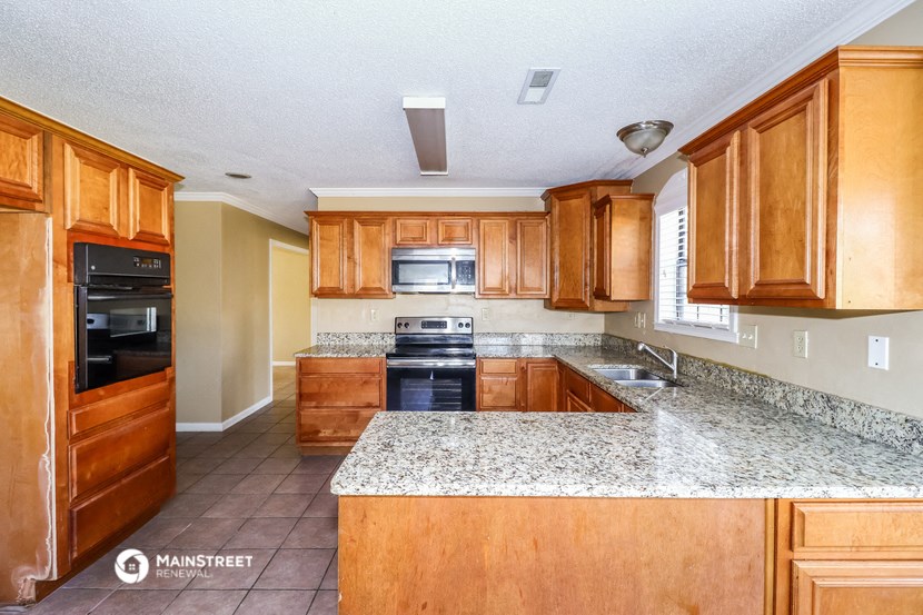 a kitchen with wooden cabinets and granite counter tops