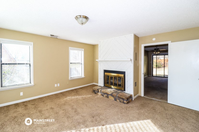 a living room with a fireplace and a carpeted floor