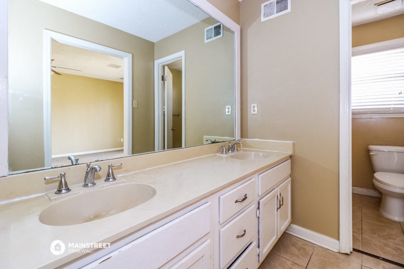 a bathroom with two sinks and a large mirror