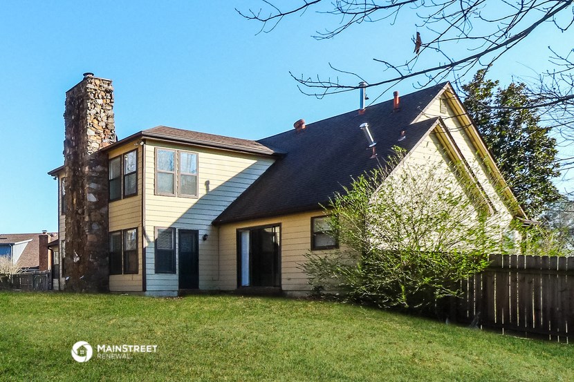 a yellow house with a chimney on the side