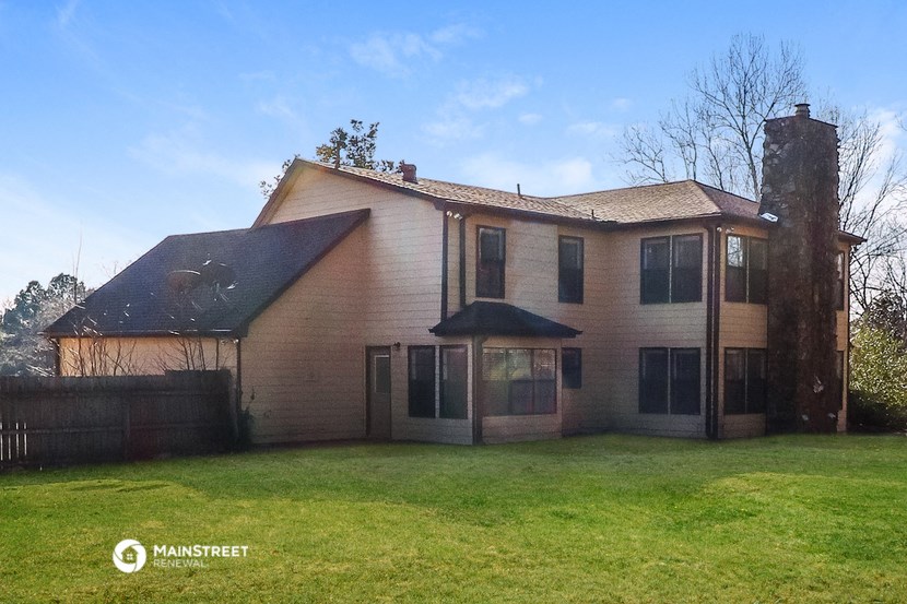 a large house with a yard and a fence