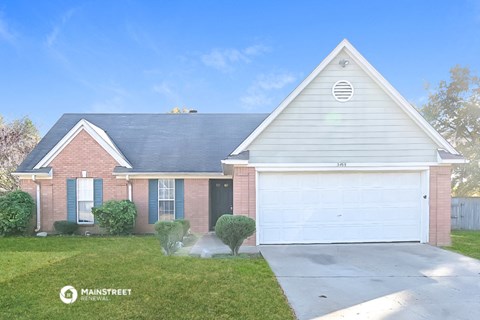 a home with a white garage door and a brick house