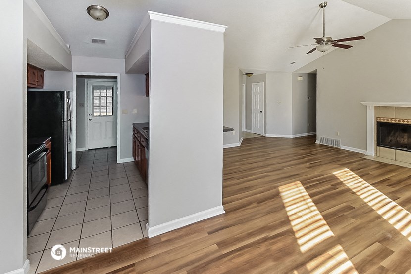 a living room with a fireplace and a wooden floor
