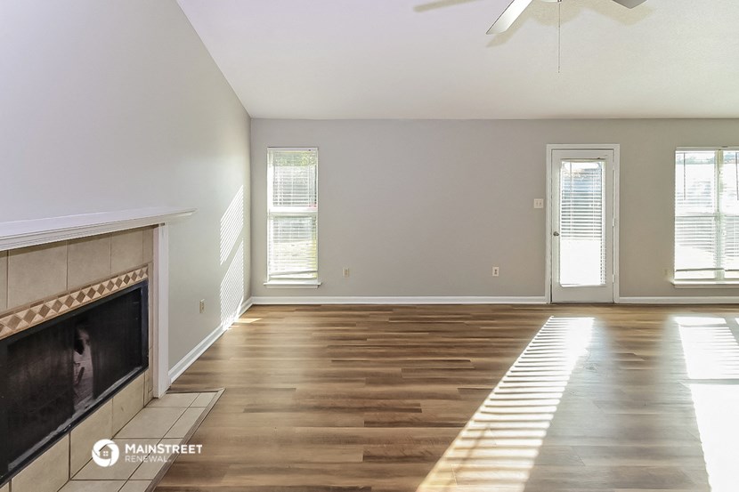 an empty living room with wood floors and a fireplace