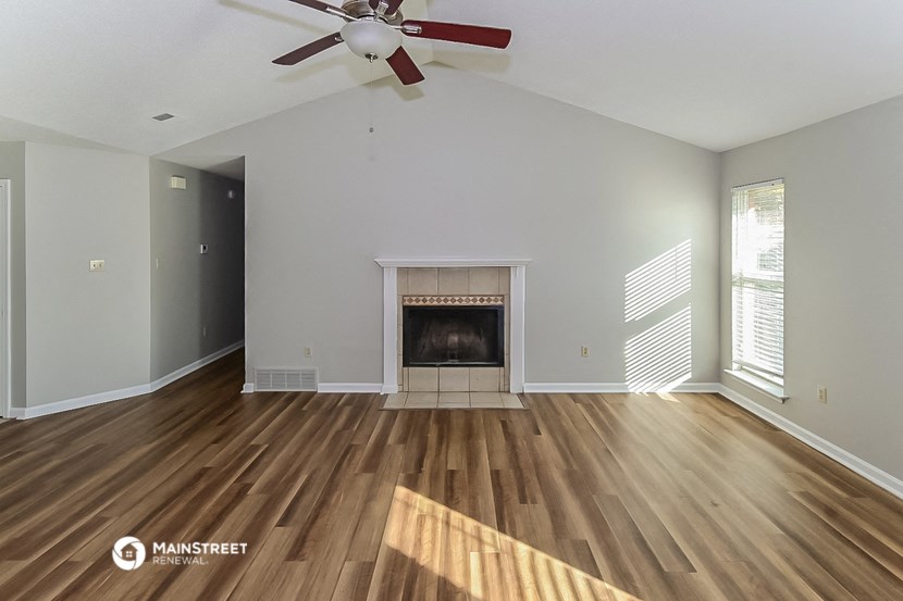 the living room with wood flooring and a fireplace