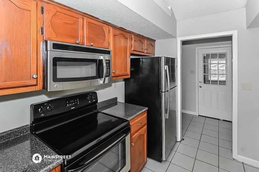 a kitchen with black appliances and wood cabinets