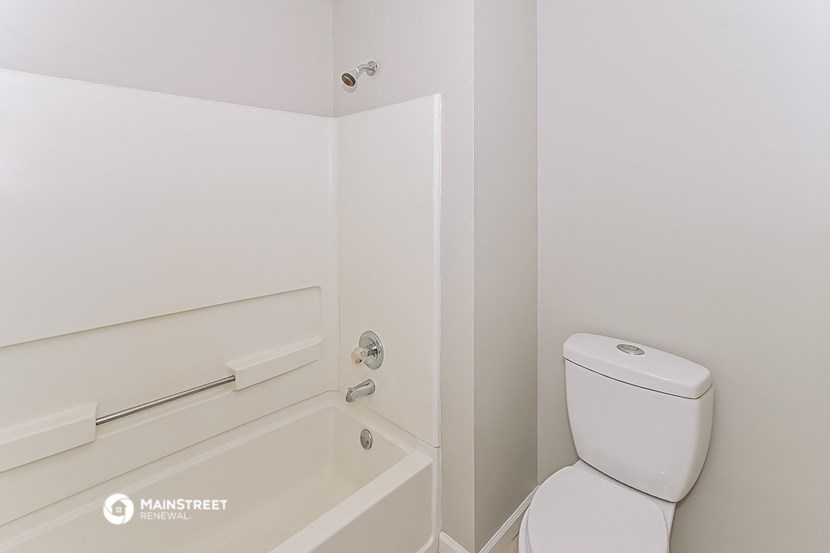 a bathroom with a toilet and a bath tub