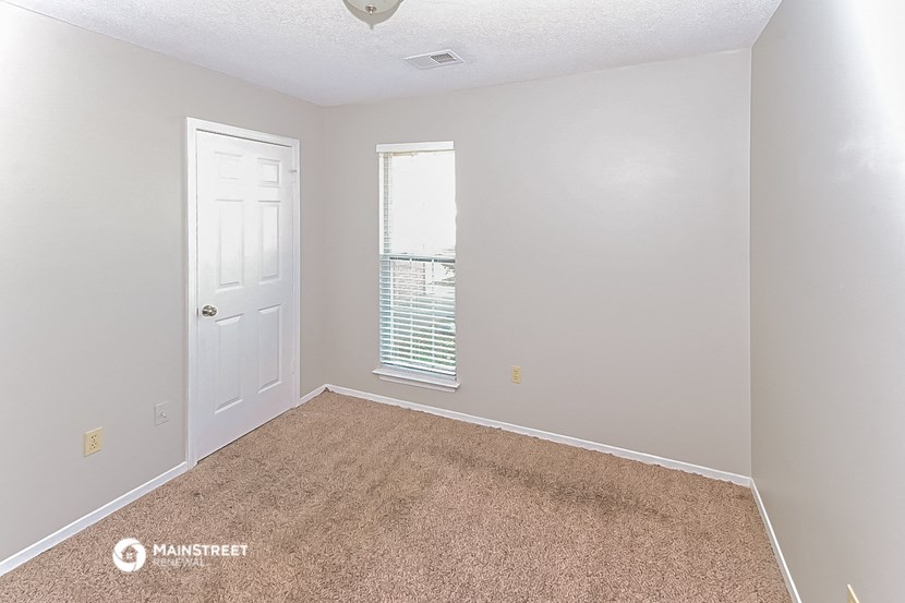 an empty room with a door and a window