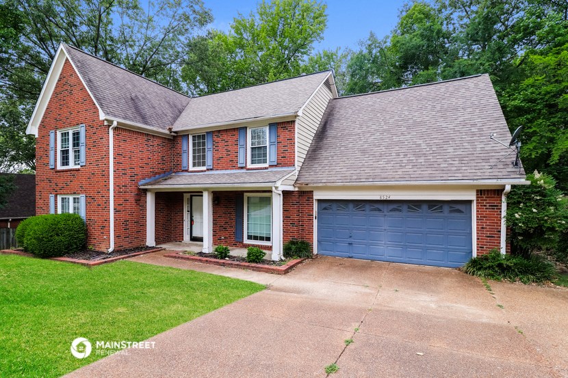 a brick house with a driveway and a blue garage door