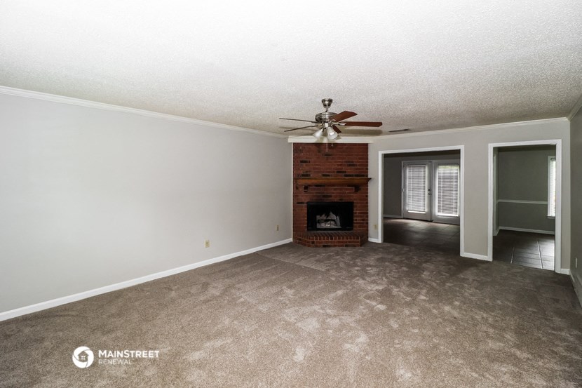 a living room with a fireplace and a ceiling fan