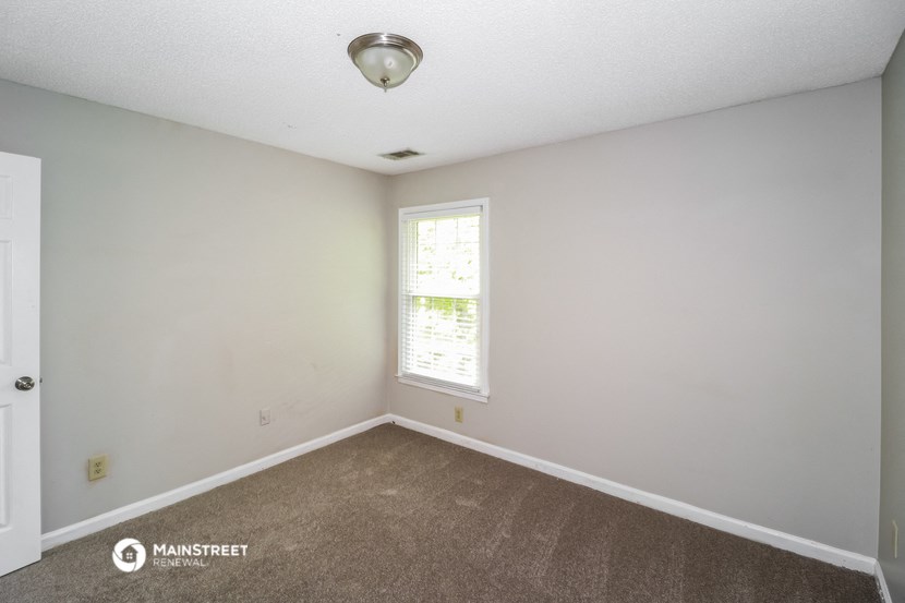 an empty room with carpet and a window