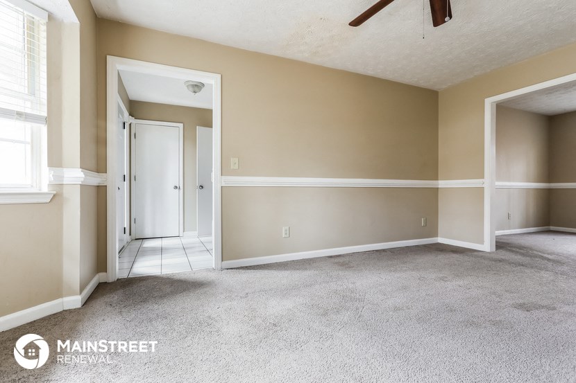 the living room of an empty house with a carpeted floor