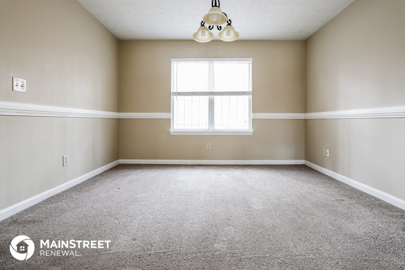 an empty room with a window and a ceiling lamp