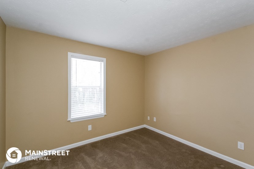 the interior of a bedroom with a carpeted floor and a window