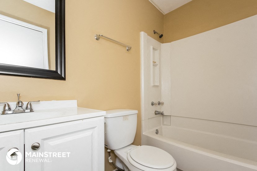 a bathroom with a toilet and a tub and a sink