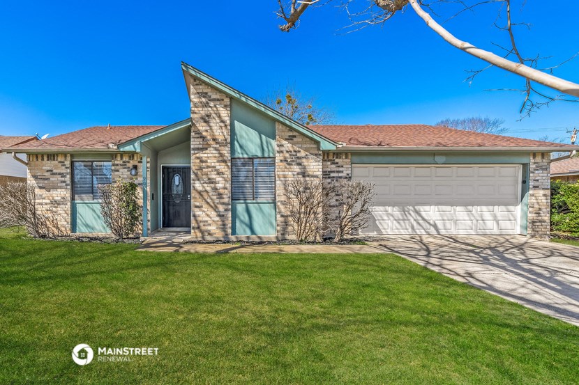 the front of a house with a lawn and a garage door