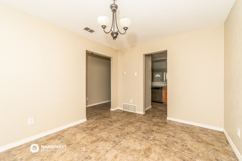 the living room of an empty house with a door to the bathroom