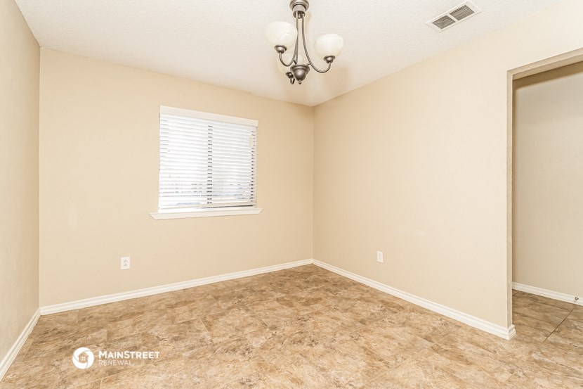 the spacious living room with a window and a door to the closet