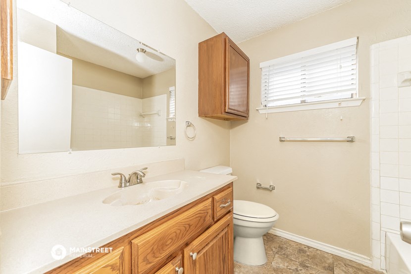 a bathroom with a toilet and a sink and a mirror