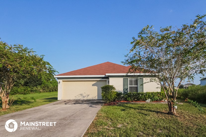 a house with a driveway and a tree in front of it