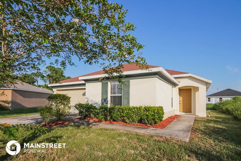 a small house with a yard and a tree