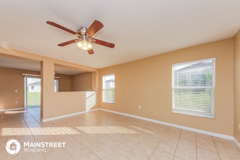a living room with a ceiling fan and a tile floor