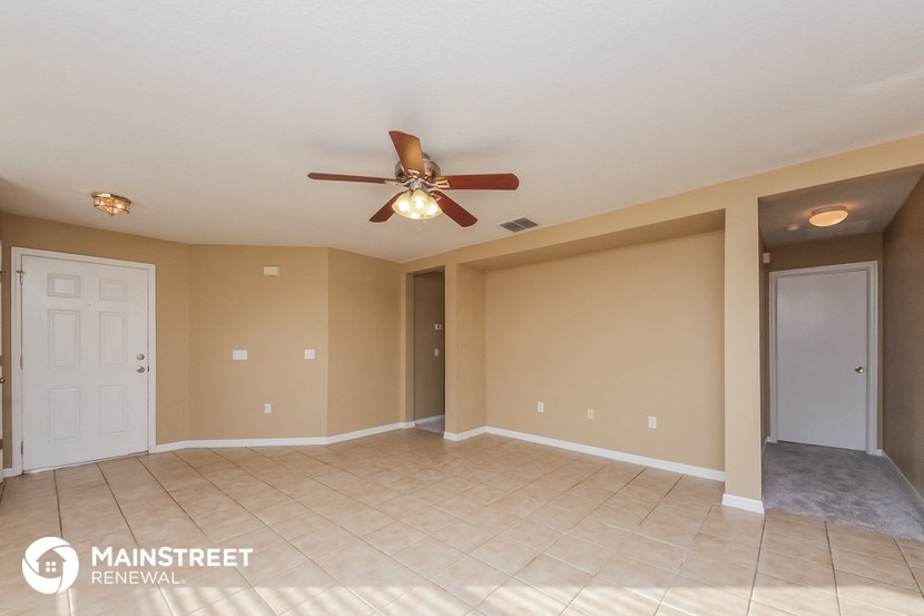 a living room with a ceiling fan and a tile floor