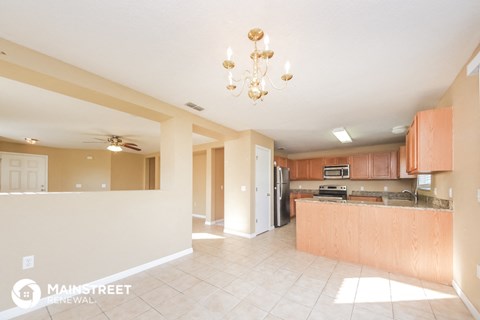 a large kitchen with wood cabinets and a chandelier