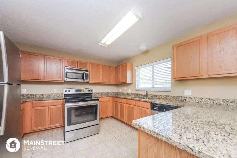 a kitchen with wooden cabinets and granite counter tops and stainless steel appliances