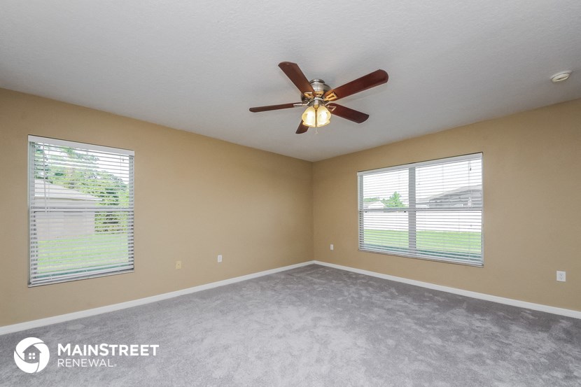 the master bedroom has a ceiling fan and two windows