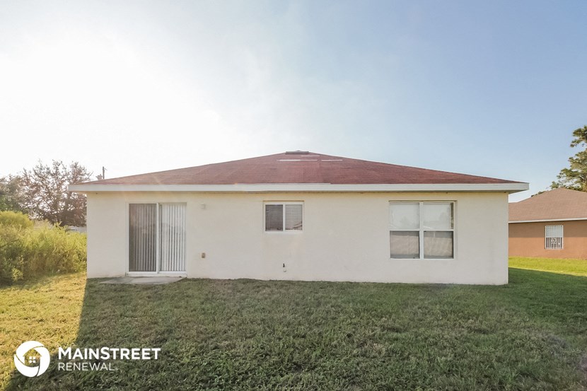 a small white house with a yard in front of it