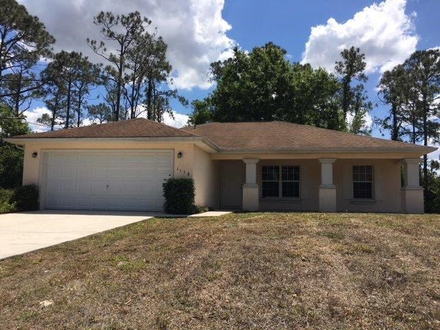 a white house with a yard and a white garage door