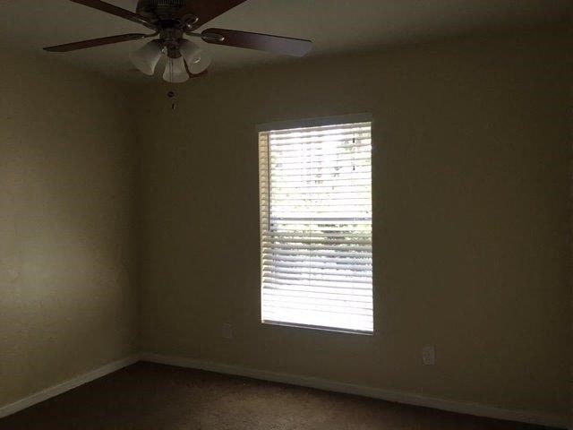 a living room with a ceiling fan and a window