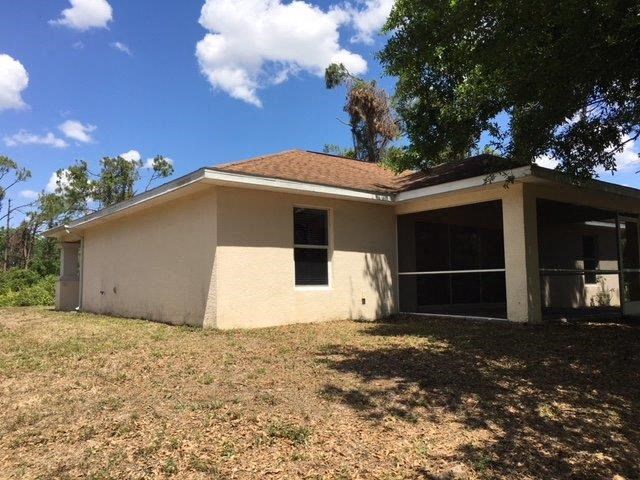 a small white house with a yard and a tree