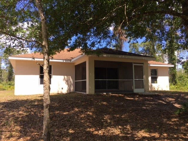 a small house with a tree in front of it