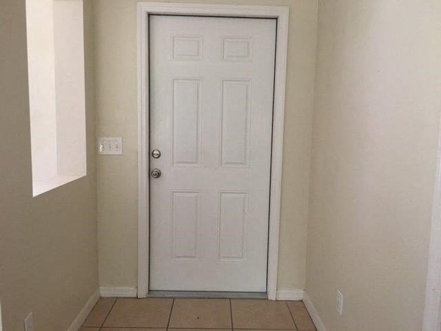 a white door in a hallway with a tiled floor