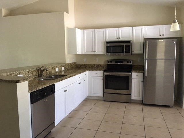 a kitchen with stainless steel appliances and white cabinets