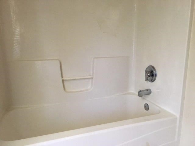 a white bath tub with a silver faucet in a bathroom