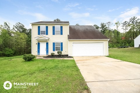 a white house with blue shutters and a driveway