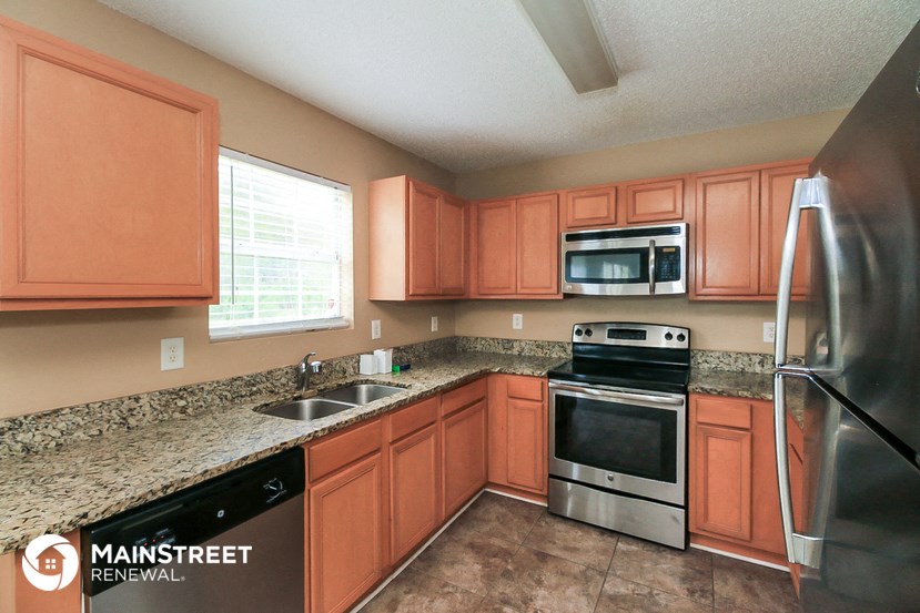 a kitchen with wooden cabinets and granite counter tops and stainless steel appliances