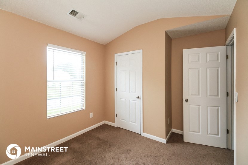 a bedroom with two white doors and a carpeted floor