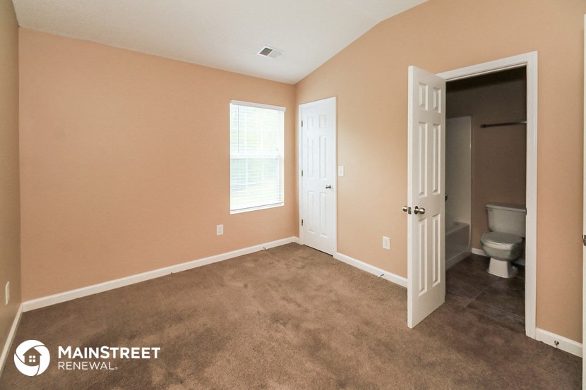 an empty room with a toilet and a door to a bathroom